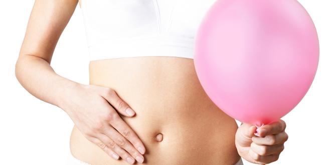 a woman feeling bloated, holding a balloon as a metaphor